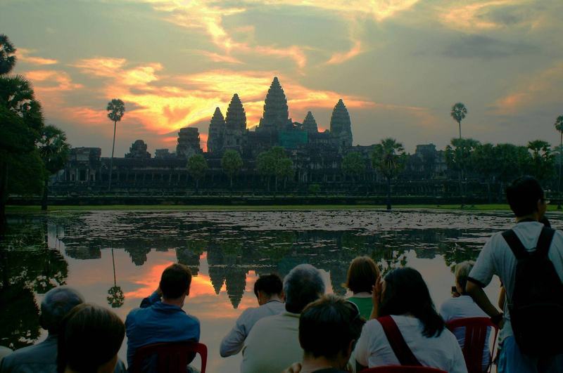 Angkor Wat at sunrise and the carved faces of Bayon temple