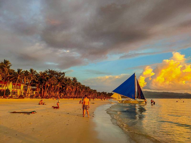 Children playing on Boracay’s White Beach with clear water in the background