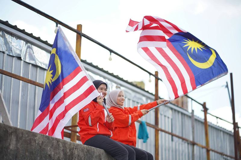 People celebrating Merdeka Day with Malaysian flags and national pride